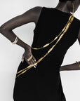 Adele Dejak Aminata Trio Set – a handcrafted trio of gold-tone brass necklaces featuring alternating hammered oval and sleek bar links, available in 88 cm, 127 cm, and 154 cm lengths, offering versatile styling options from bold layering to subtle elegance-model backside-view image