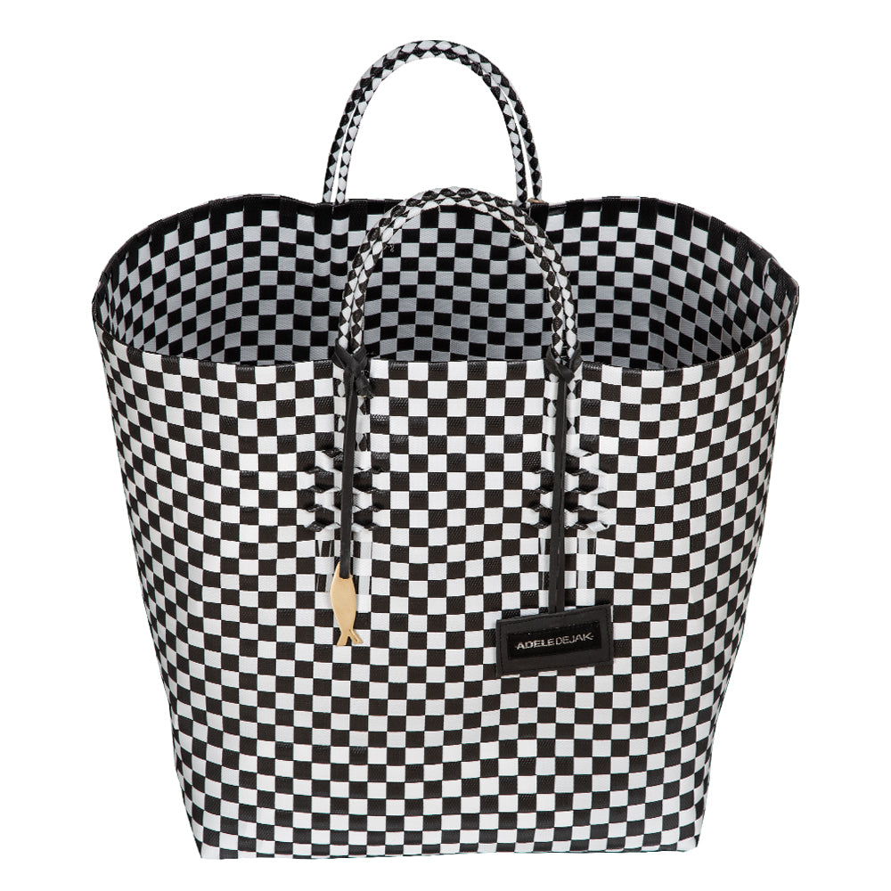 Handwoven black Theresa Bag by Adele Dejak, crafted from recycled plastic with a checkered pattern, featuring dual handles and adorned with signature brass charms, symbolizing sustainable African elegance-wide angle front view